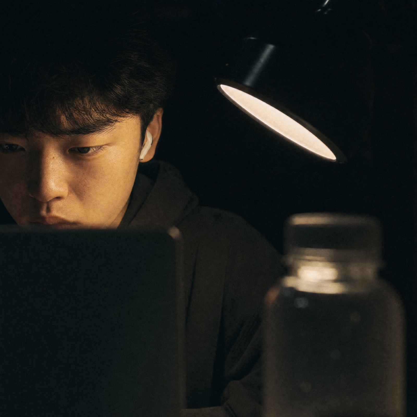 Someone working late under a desk lamp